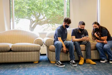 Photo: Students sitting on a couch in housing
