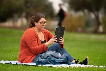 Photo: Student studying in the grass in the quad