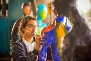 Student painting on a sculpture