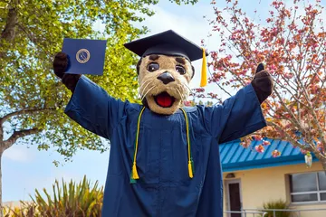 Monte wearing graduation cap and gown, holding a diploma