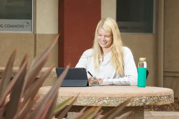 A photo of a CSUMB student studying in campus