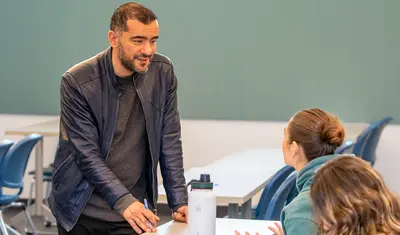Teacher talking to students during a classroom discussion.