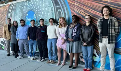 Fall 2024 Debbie Juran Award Recipients standing against mural