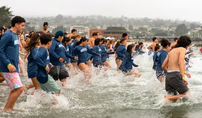 Students splash into the ocean at the Otter Plunge