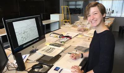 Girl sitting in front of computer and smiling