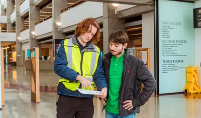 A CSO pointing out directions on a map for a student