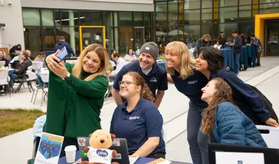 President Vanya Quiñones taking a selfie with staff members at Otter Thursday.