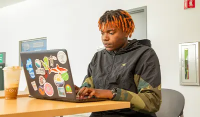 Student looking at a laptop on a desk