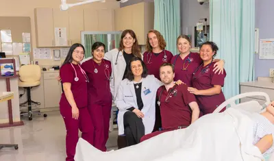 A group of nursing students and professors smiling at the camera