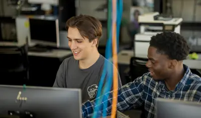 Two students collaborating together in the business and information technology building