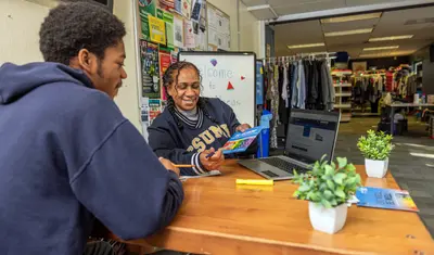 Faculty member pointing to paper with student at a table