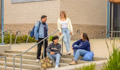 A group of four students is talking to each other.