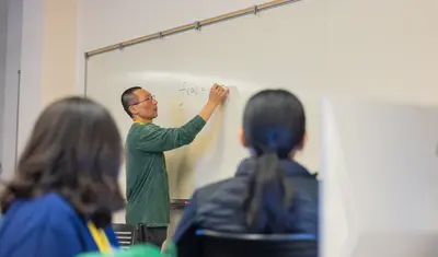Teacher writing on whiteboard
