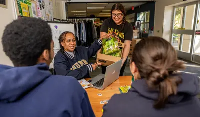 Students and a faculty member pulling a bag out of a box