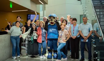 Group of iiED staff and students with CSUMB Mascot Monte Rey
