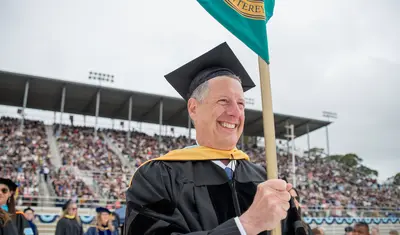 Dean holding college pole