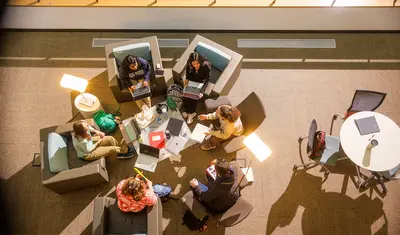 Students sitting in the library collaborating