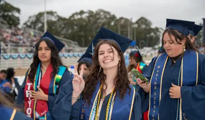 CSUMB graduate posing for a photo at commencement