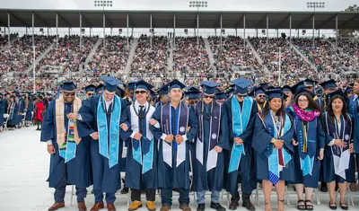 CSUMB Students joining arms at the commencement ceremony