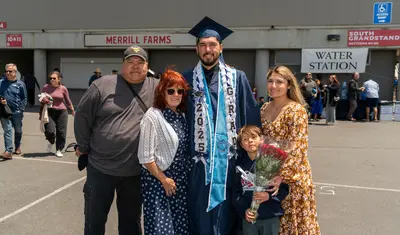 Graduate with family outside of the commencement venue