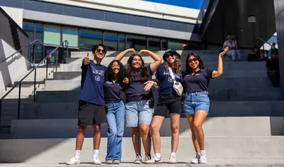 Group of student employees posed together in front of the OSU.