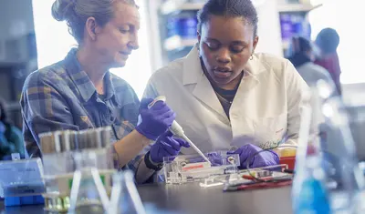 professor and student pipetting in a lab environment classroom
