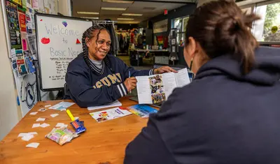 a professor showing a student a pamphlet