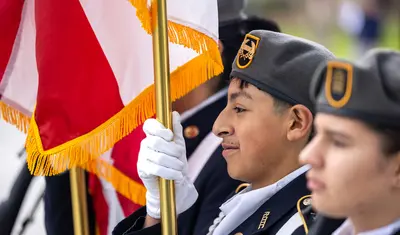 Student holding the American flag to honor veterans.