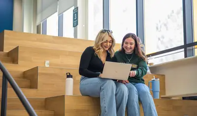 Two students sitting in the OSU looking at a laptop