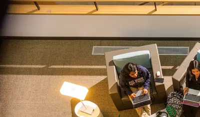 Students sitting in the library collaborating