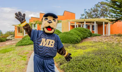 The campus mascot welcomes visitors outdoors, highlighting school spirit and a friendly, inviting environment.