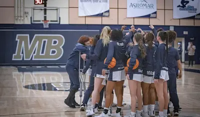Women's basketball athletes huddling