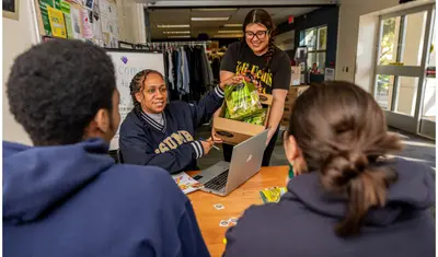 Students and a faculty member pulling a bag out of a box