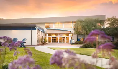 A landscape of a building with a sunset in the background