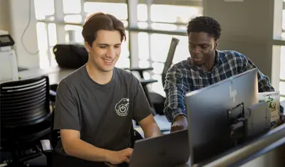 Two students collaborating together in the business and information technology building