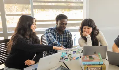 A group of students collaborating in a computer lab in the buissness and information technology building