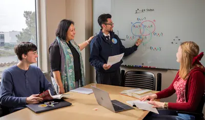 Three statistics students in a meeting with Dr. Deka