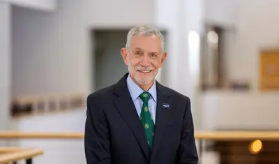 Cal State Monterey Bay Interim President Carlos Vargas smiles for a portrait inside a campus building.