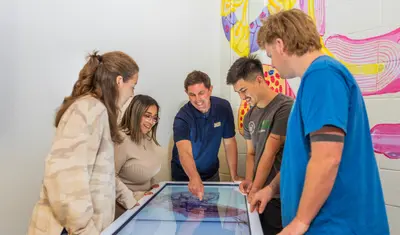 Professor showing students a diagram of something in class.