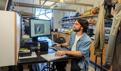 Student looking at a computer screen in a classroom.