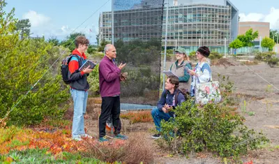 CSUMB environmental science students listen as faculty explains field observations during an outdoor campus field lesson.