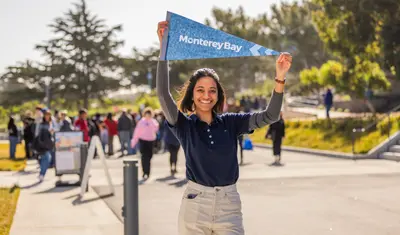 Student holding flag above their head