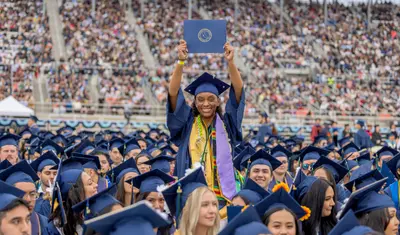 Student at Commencement holding diploma