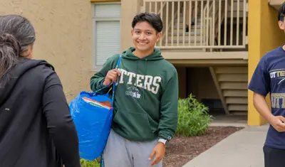 Student carrying a bag of belongings to move in