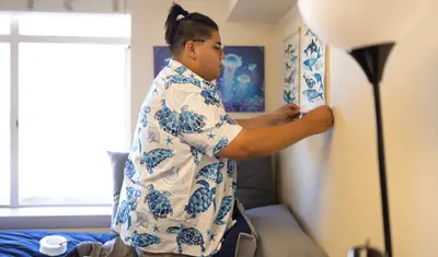 Person hanging poster on the wall