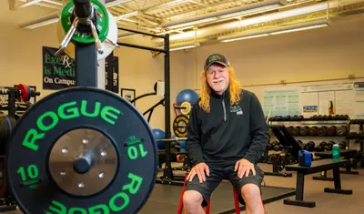 Professor sitting for a portrait in a gym.