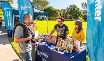 CSUMB staff talk to a parent and prospective student at 2025 Open House