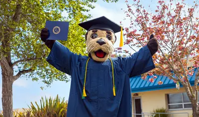 Monte wearing graduation cap and gown, holding a diploma