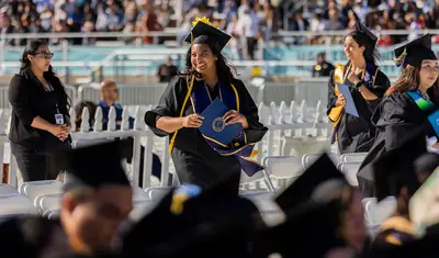 Photo: Graduate walking and holding diploma