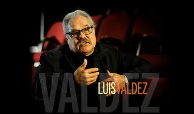 Luis Valdez photo of him speaking and gesturing with hands